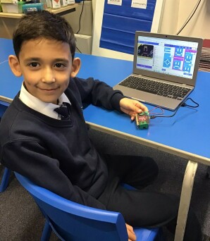 A student using a Chromebook to code a microbit computer.